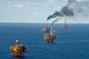 Luftaufnahme mehrerer Ölförderplattformen im offenen Meer.