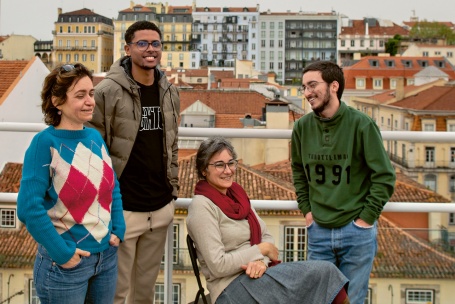 Auf einer Terrasse über den Dächern von Lissabon haben sich die vier Mitstreiter der Genossenschaft zu einem lockeren Gruppenbild versammelt.